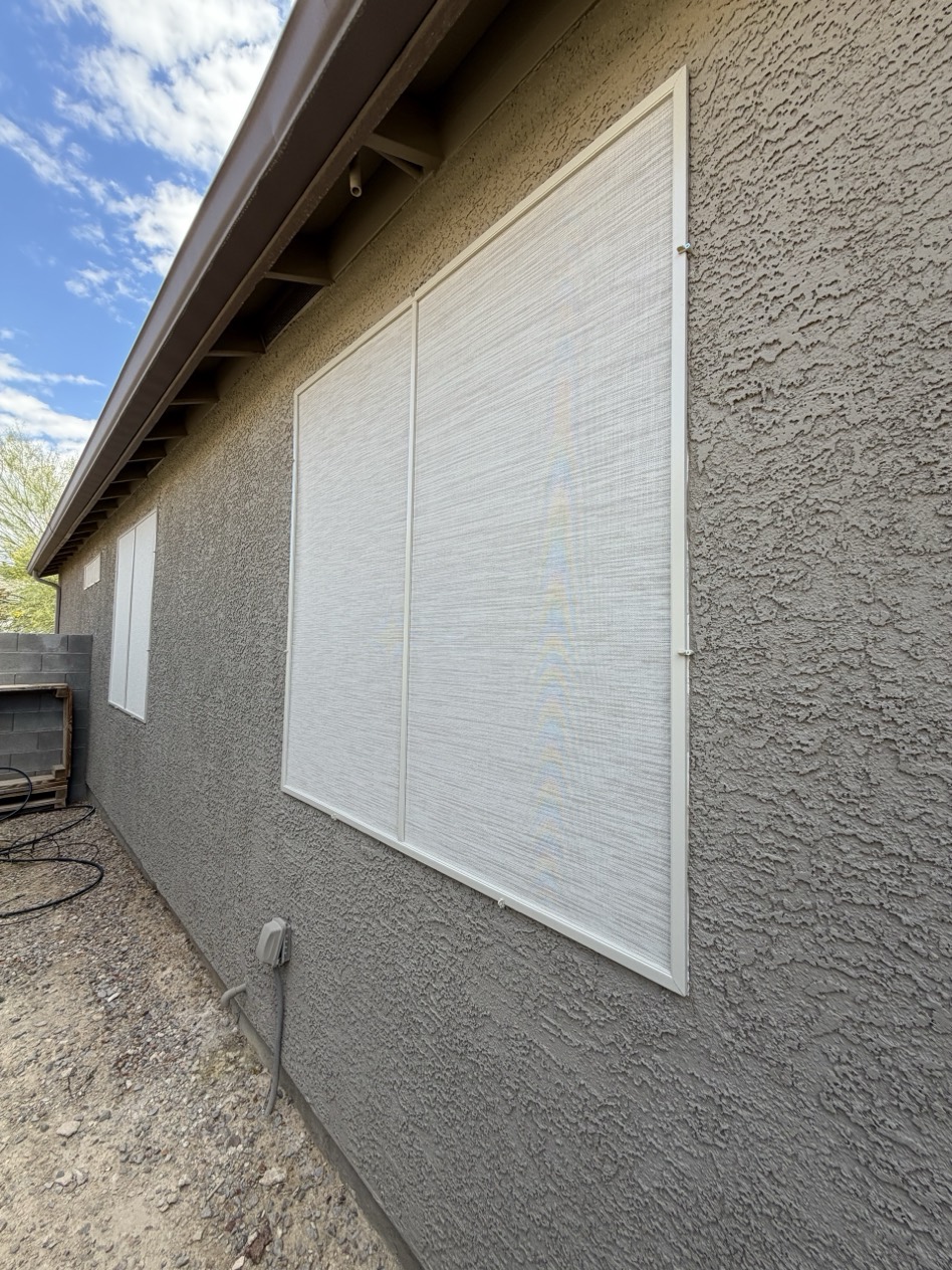Custom solar screens installed on a Las Vegas stucco home — white fabric with white aluminum frames blocking heat and UV before it reaches the glass