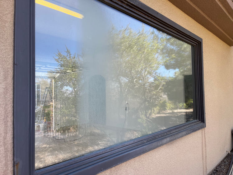 Picture window with heavy hard water etching before professional cleaning in Las Vegas