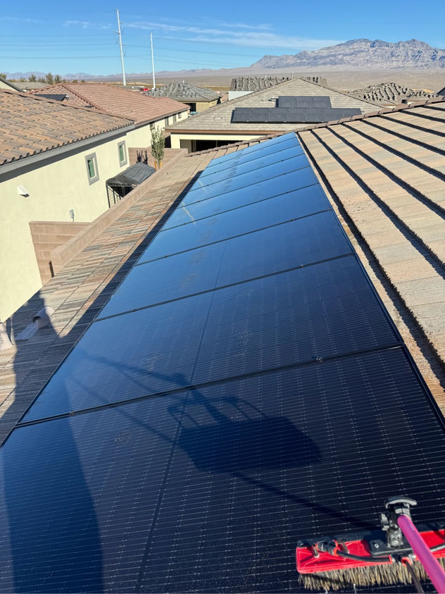 Freshly cleaned residential solar panels gleaming on a Las Vegas rooftop with Red Rock Canyon mountains in the background