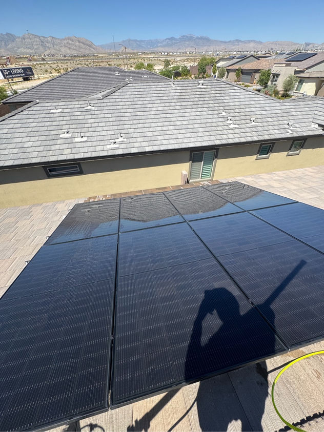 Solar panel cleaning in progress on a Las Vegas rooftop with desert mountains visible in the background