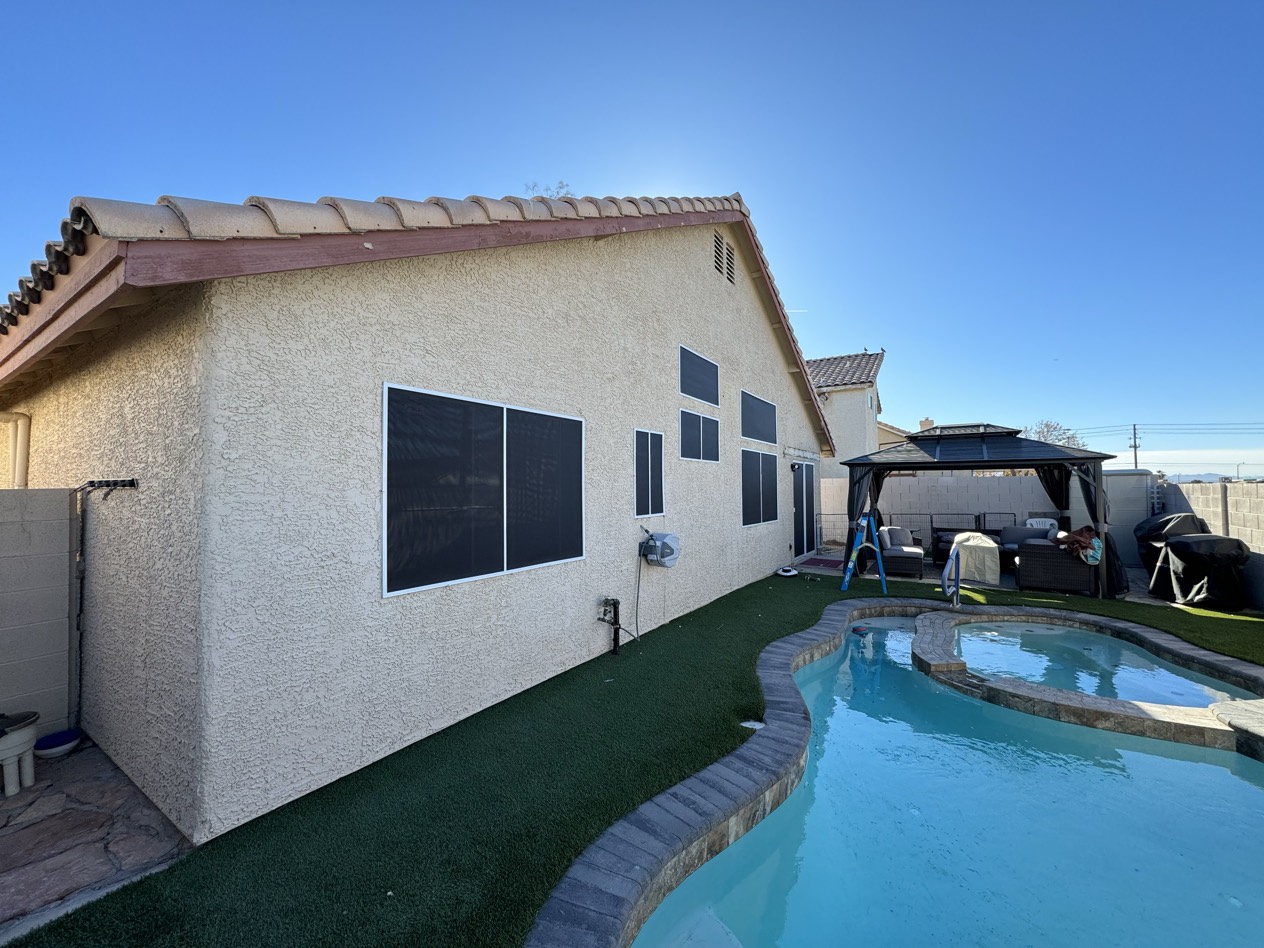 Close-up of a custom solar screen installation on a Las Vegas home — flush fit to the window opening with no gaps or rattling