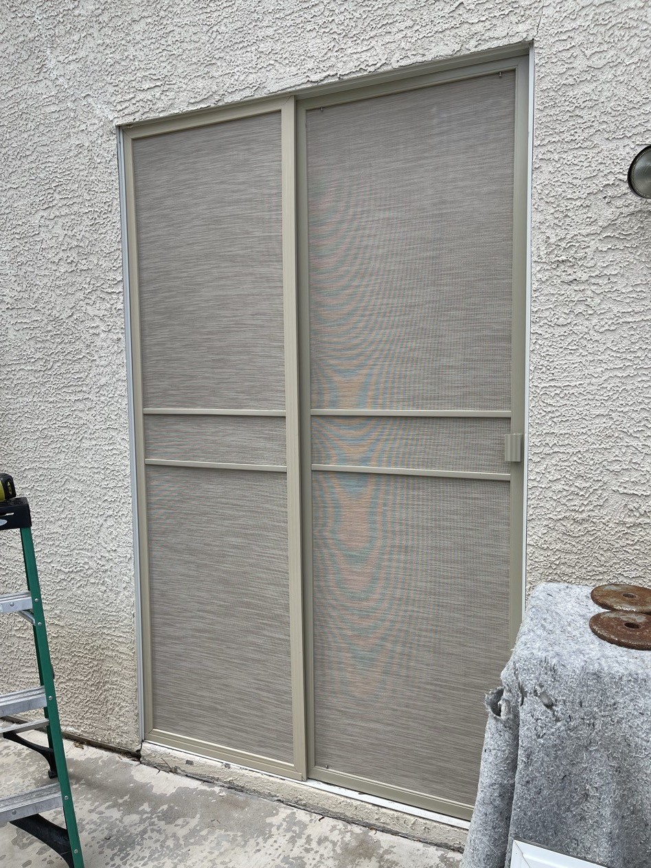 Custom solar screen door and stationary solar screen installed on a Las Vegas stucco home — matching beige fabric and frame