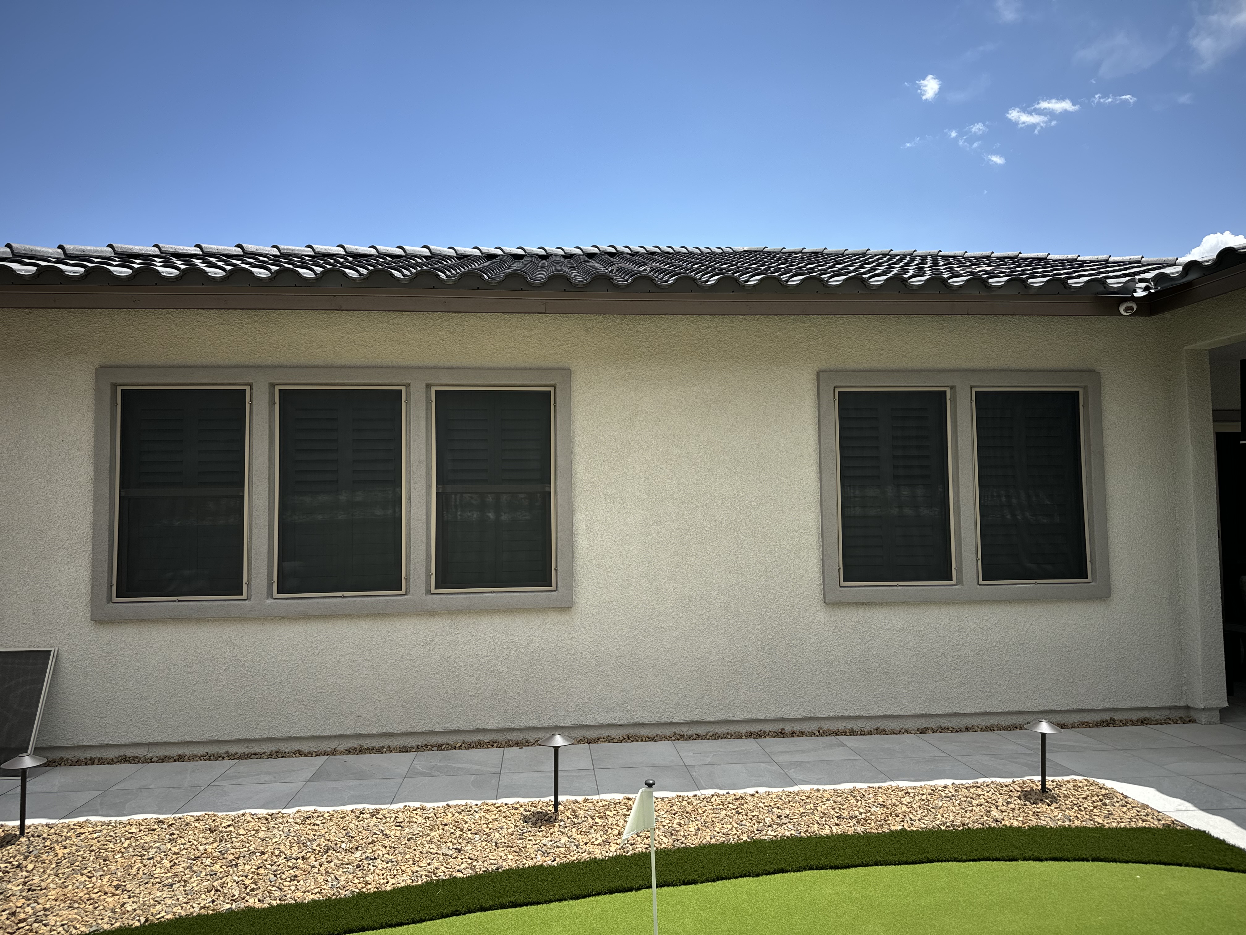 Solar sun screens installed on a Las Vegas home — full curb-appeal exterior view showing the clean look across multiple windows